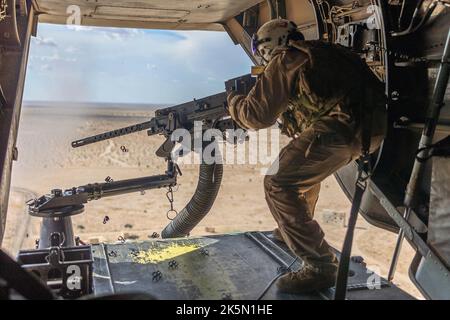 Yuma, United States. 06 October, 2022. U.S. Marines Corps Sgt. Juan Gutierrez with Marine Medium Tiltrotor Squadron 268, Marine Aircraft Group 24, 1st Marine Aircraft Wing, fires an M240D 7.62mm machine gun out of an MV-22 Osprey aircraft during Weapons and Tactics Instructors course at Goldwater Air Force Range, October 6, 2022 near Yuma, Arizona. Stock Photo