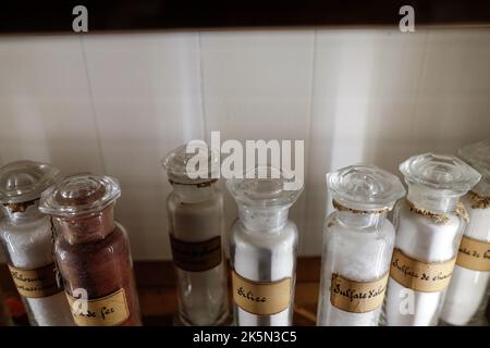 Shallow depth of field (selective focus) details with various glass vials used for old chemical and medical experiments inside a museum. Stock Photo