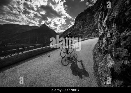 Male road cyclist riding up the balcony road from Bourg d'Oisans to Villard Notre Dame, French Alps. Stock Photo