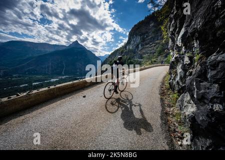 Male road cyclist riding up the balcony road from Bourg d'Oisans to Villard Notre Dame, French Alps. Stock Photo