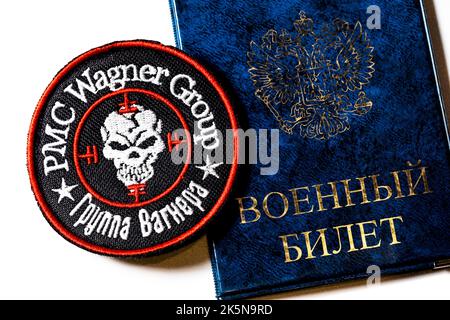 View of a logo of the Russian private security company 'Wagner Group' and Russian military ID on white background Stock Photo