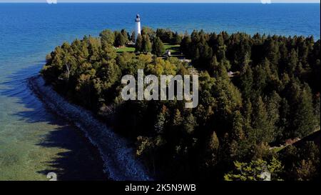 Wisconsin, USA. 30th Sep, 2022. The Cana Island Lighthouse on the north tip of Spike Horn Bay is located at 8800 E Cana Island Rd Baileys Harbor, Wisconsin. In 2019 the structure celebrated 150 years of standing watch on the shore of Lake Michigan. Ride a hay-wagon over the causeway to explore the island, including the 89-foot-tall light tower, oil storage house and lighthouse keeper's home. The highlight of any Cana Island visit is climbing the 97 steps of the tower's spiral staircase to reach the gallery deck, which delivers a sweeping panoramic view of Lake Michigan and the Door Cou Stock Photo