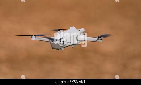 Modern lightwight mini drone or quadcopter with camera cut out in flight Stock Photo