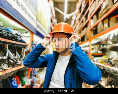 a man measures a helmet in a store Stock Photo