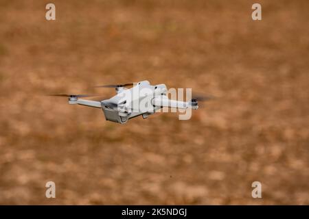 A camera drone or multicopter flying exempted over a field Stock Photo