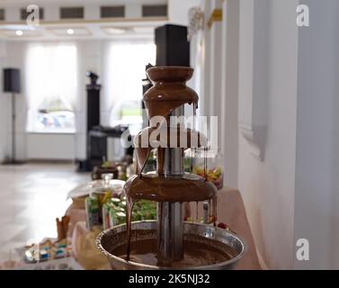Chocolate fountain at the party. Celebration party with a chocolate fountain. Stock Photo