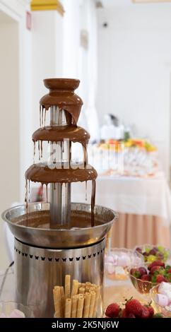 Chocolate fountain at the party. Celebration party with a chocolate fountain. Stock Photo