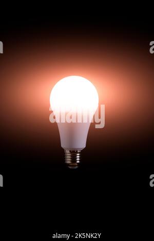 Burning LED eco friendly light bulb on black background Stock Photo