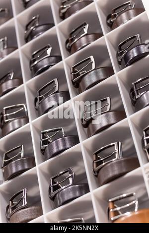 Various coloured leather belt display on shelf in the store in a men clothing boutique. Small depth of field. Fashion and clothing concept Stock Photo