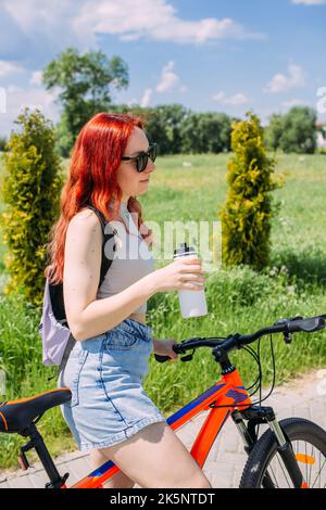 Young woman in the city rides bike and leads an active lifestyle doing sports Stock Photo