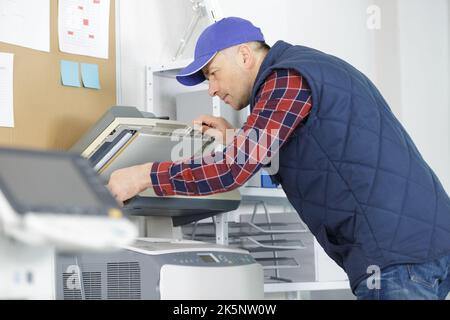 technician repairing an office photocopier Stock Photo
