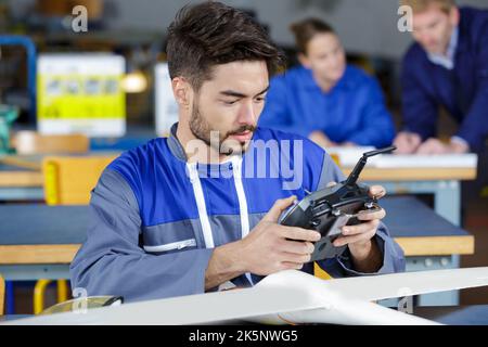 young engineer at desk with remote control aircraft Stock Photo