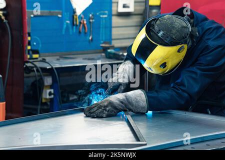 welder at work, welding metal parts in workshop Stock Photo
