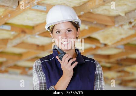 happy female construction worker using talkie walkie Stock Photo