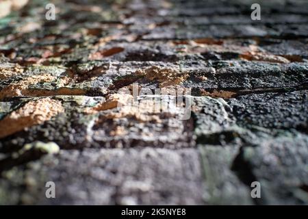 Worn brick wall with flaking and peeling paint from low perspective looking up Stock Photo