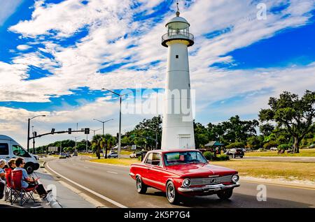 A 1964 Plymouth Valiant Signet passes the Biloxi lighthouse during the 26th annual Cruisin’ the Coast antique car festival in Biloxi, Mississippi. Stock Photo