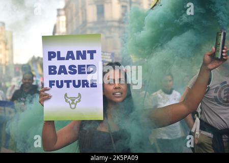 London, UK. 8th Oct, 2022. Animal Rights activist holds a placard and smoke flare during the protest. Animal Rebellion joined with environmentalists from Just Stop Oil, vegans and animal rights activists took to the streets of central London calling for a Plant-based Future. (Credit Image: © Thomas Krych/ZUMA Press Wire) Stock Photo