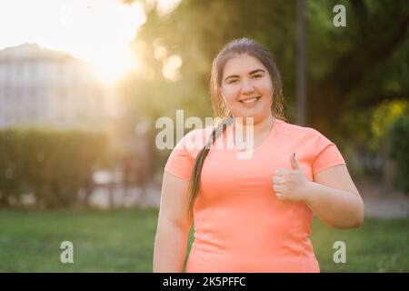 thumbs up gesture happy plus size overweight woman Stock Photo