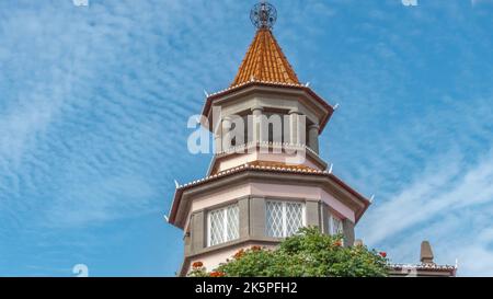 Octagonal tower building against a blue sky with a unique round metal ball on the top Stock Photo