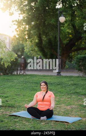 yoga outdoors mind wellness overweight woman park Stock Photo