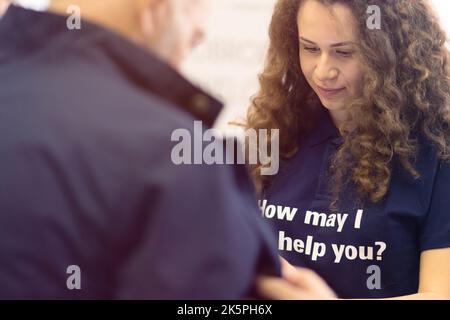 Conference Staff Member scan a QR code from attendee upon arrival to check-in site Stock Photo