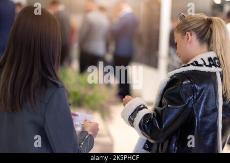 Conference Staff Member scan a QR code from attendee upon arrival to check-in site Stock Photo