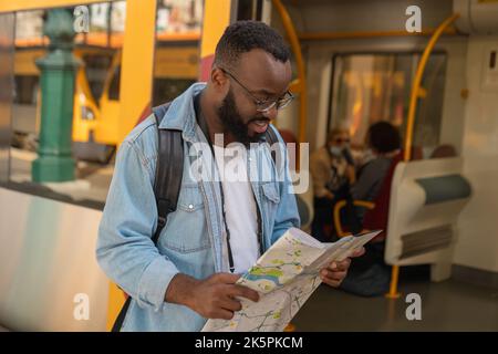Young adult man with map at terminal train station Stock Photo
