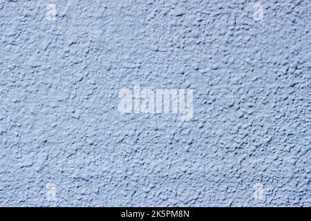 Plastered and painted uneven surface wall. Concrete texture of light blue color Stock Photo
