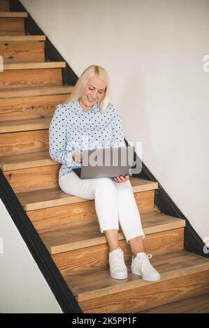 Joyous woman talking to somebody during the video call Stock Photo
