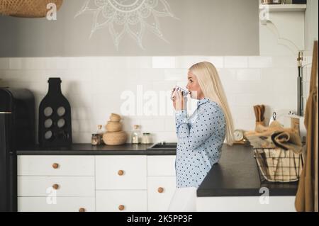Thoughtful mature lady sipping a beverage at home Stock Photo