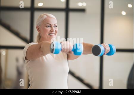 Joyful woman working out with hand weights Stock Photo