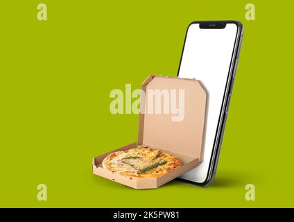Smartphone and pizza box on green background. Food delivery Stock Photo