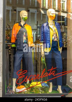 Mannequins in colorful masks behind the window of the shop Escarlata, Madrid, Spain Stock Photo