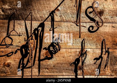 Branding tools on a wood wall Stock Photo