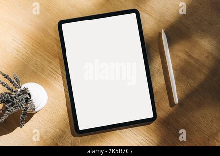 Tablet mock-up in the natural sunlight. Empty white screen, minimalist design, place for text Stock Photo