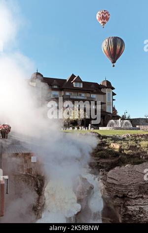 Gas from the geothermal hot springs on the banks of the San Juan River, the Springs Resort, and hovering hot air balloons in Pagosa Springs, Colorado. Stock Photo