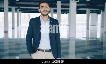 portrait of Arab businessman standing indoors empty industrial building and looking at camera. Real estate deals and renting concept. Stock Photo