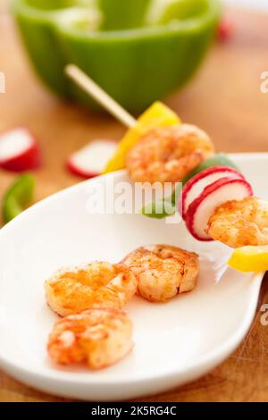Delicious decadence. Closeup of a prawn skewer placed on a plate. Stock Photo