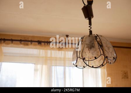Chandelier in old interior. Lamp in room. Light from window. Details of room. Stock Photo