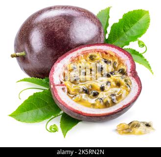 Dark purple passion fruit and half of fruit with green leaves on white background. Stock Photo