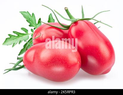 Three pink tomatoes (plums) with tomato leaves isolated on white background. Stock Photo