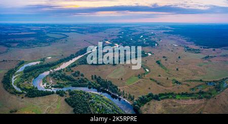 Beautiful Ukrainian nature background. Drone view on riverbank of the Seym river and amazing cloudscape over it. Summertime. Stock Photo