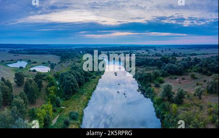 Beautiful Ukrainian nature background. Drone view on riverbank of the Seym river and amazing cloudscape over it. Summertime. Stock Photo