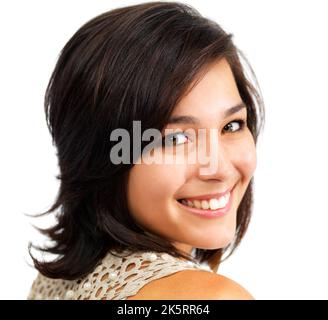 Shining face of the next generation. Sweet young woman smiling cheekily over her shoulder at you, isolated on white. Stock Photo