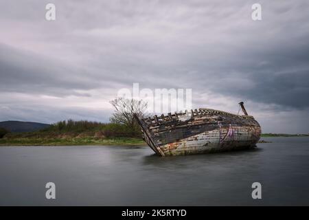 The shipwreck of Bad Eddie on the shore of Magheraclogher Beach under overcast sky in Donegal, Ireland Stock Photo
