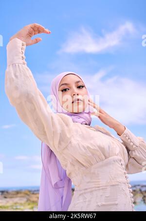 Beautiful young arab woman posing outdoors in a headscarf. Attractive female muslim wearing a hijab posing outside. Shes all about style and fashion Stock Photo