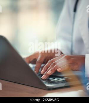 Doctor working on their laptop in the hospital. hands of a doctor typing on their computer sitting at the desk. Closeup on hands of medical Stock Photo