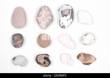 Beautiful beach pebbles and rocks idsolated on a white background. Speckled, brown, white and patterened natural rocks Stock Photo