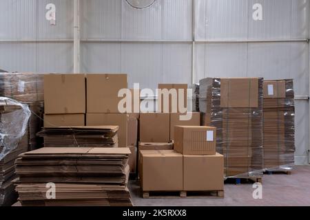 Large Retail Warehouse With Goods In Cardboard Boxes And Packages. Logistics, Sorting and Distribution Facility for More Product Delivery. Front View Stock Photo