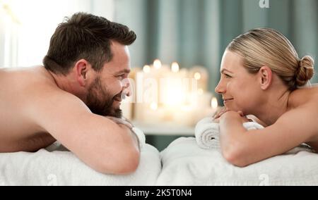 Couple, spa and luxury massage together for healthy, relax and wellness at a holiday resort. Happy man and woman in relationship looking at each other Stock Photo